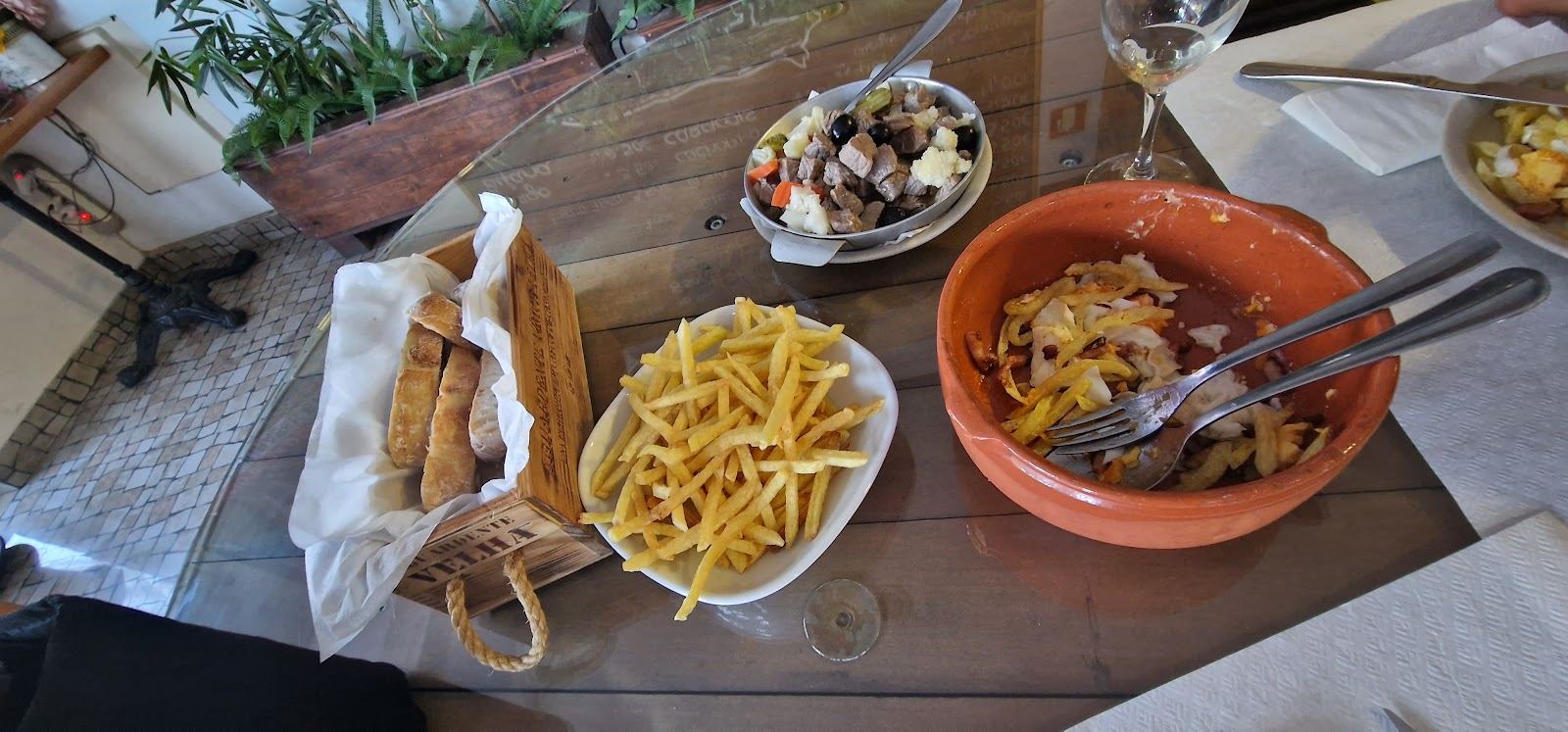 Mesa com petiscos e batatas fritas na Taverna Pica Cebola